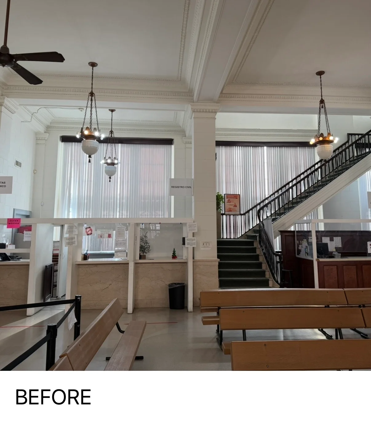 Historic building interior with painted ceilings, crown molding, and grand staircase