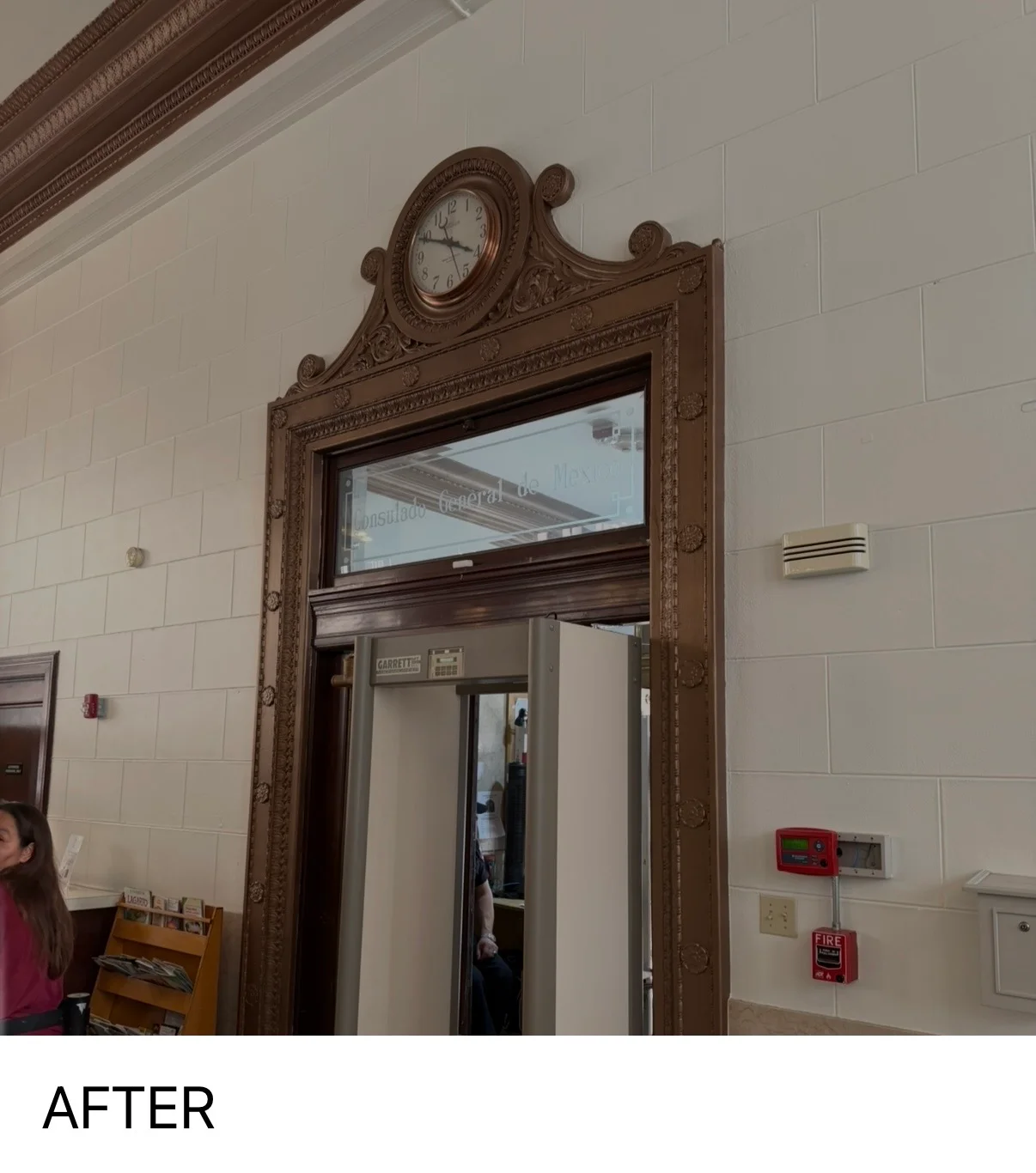 Freshly painted white walls with ornate dark wood door frame and decorative clock in commercial interior