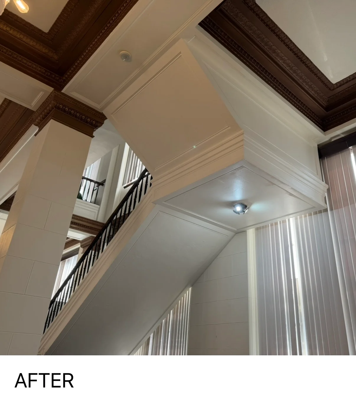 Freshly painted white ceiling with dark decorative beams and crown molding in residential interior