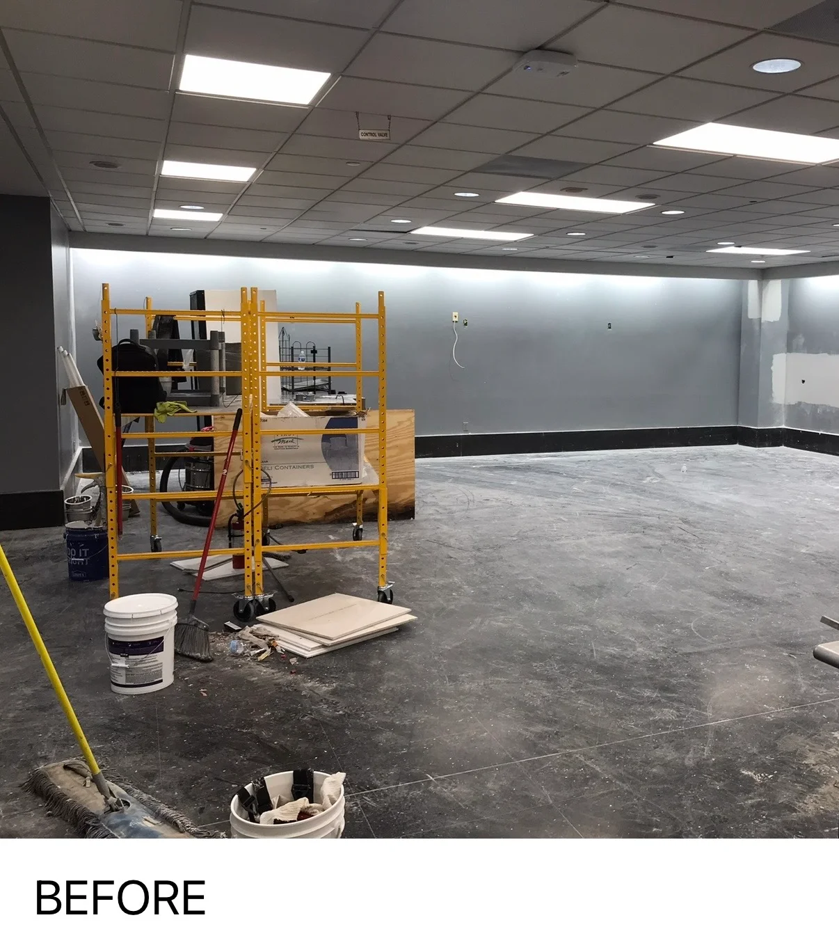 Commercial interior space with new drywall, recessed lighting, and concrete floor under construction