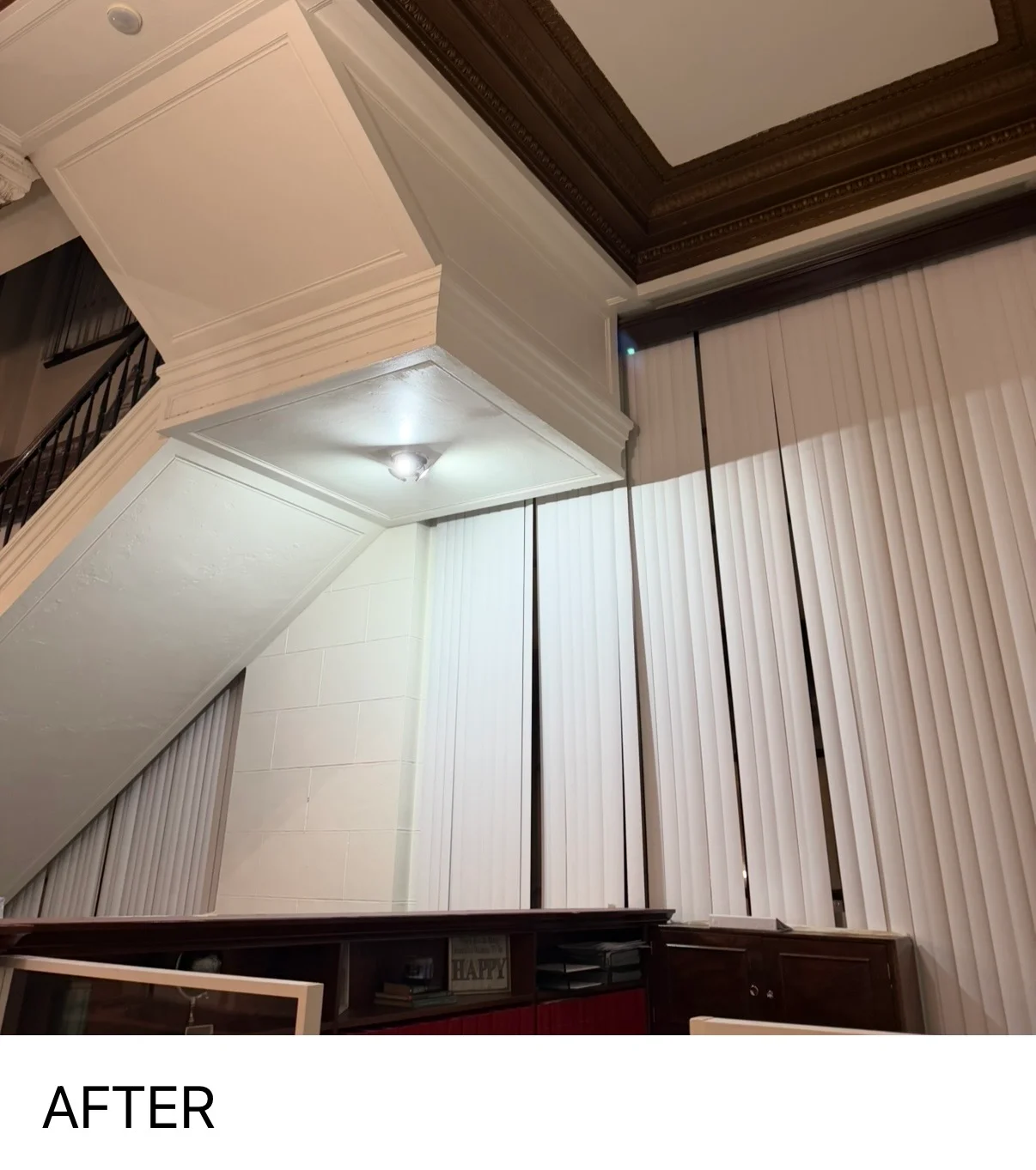 Freshly painted white vaulted ceiling with crown molding and vertical blinds in residential space