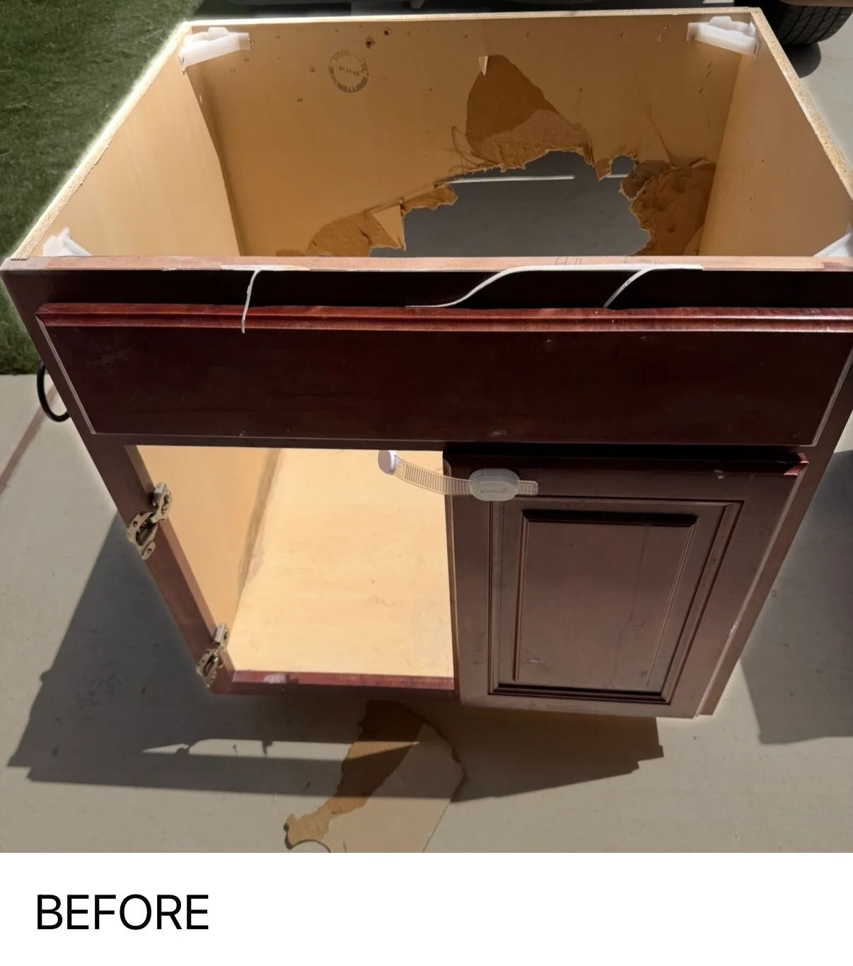 Before photo of burgundy cabinet with damaged interior cardboard backing and water stains