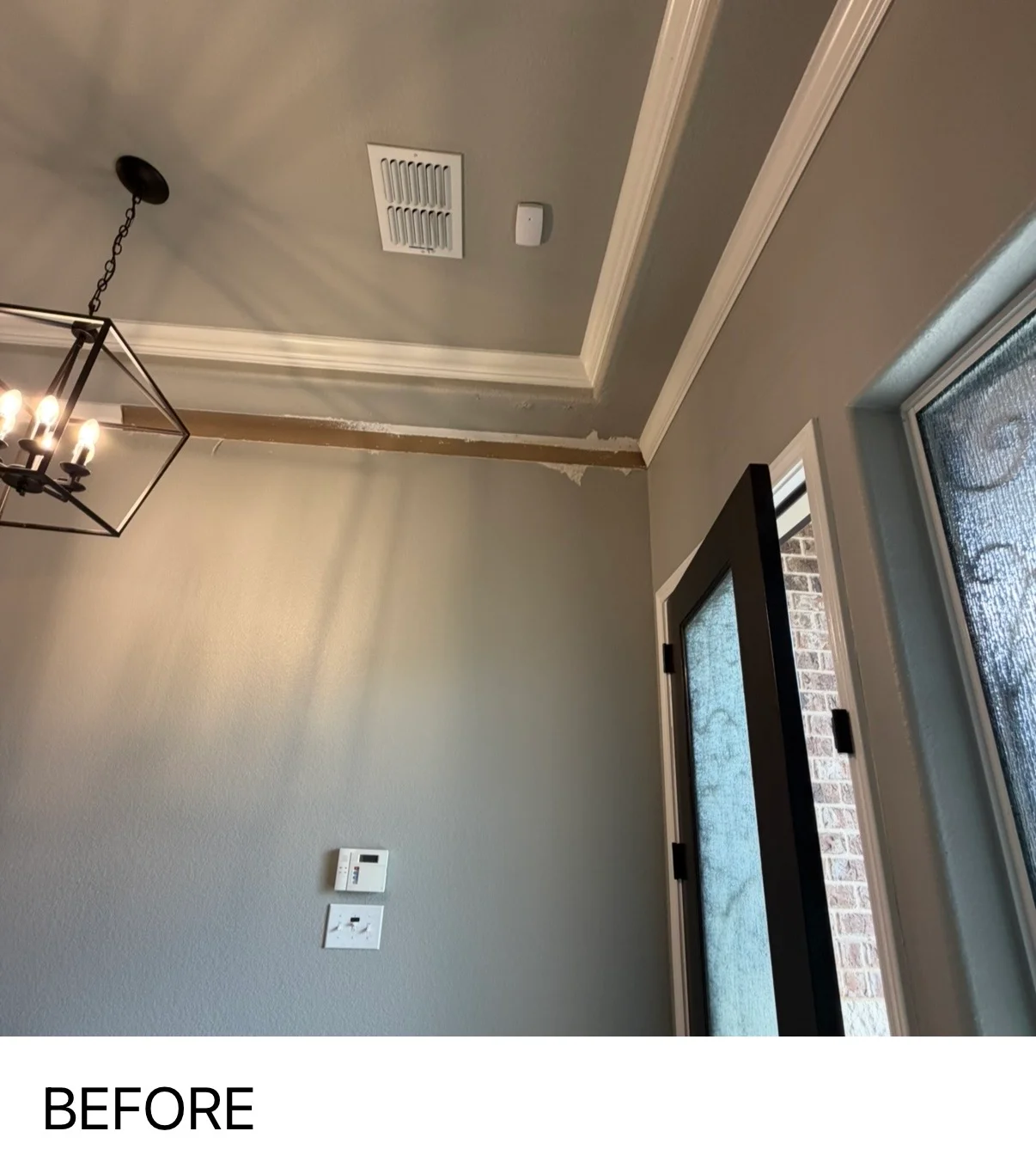 Freshly painted interior room with coffered ceiling, white trim, and taupe walls