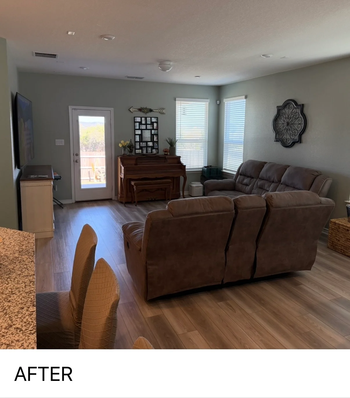 Freshly painted living room with neutral walls, brown leather furniture, and recessed ceiling lights