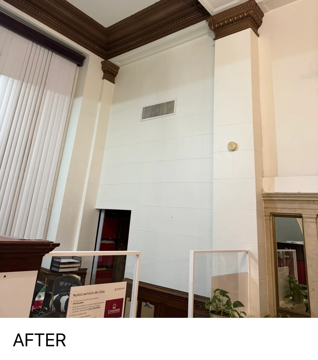 Freshly painted white interior walls with dark wood crown molding and trim in high-ceiling room