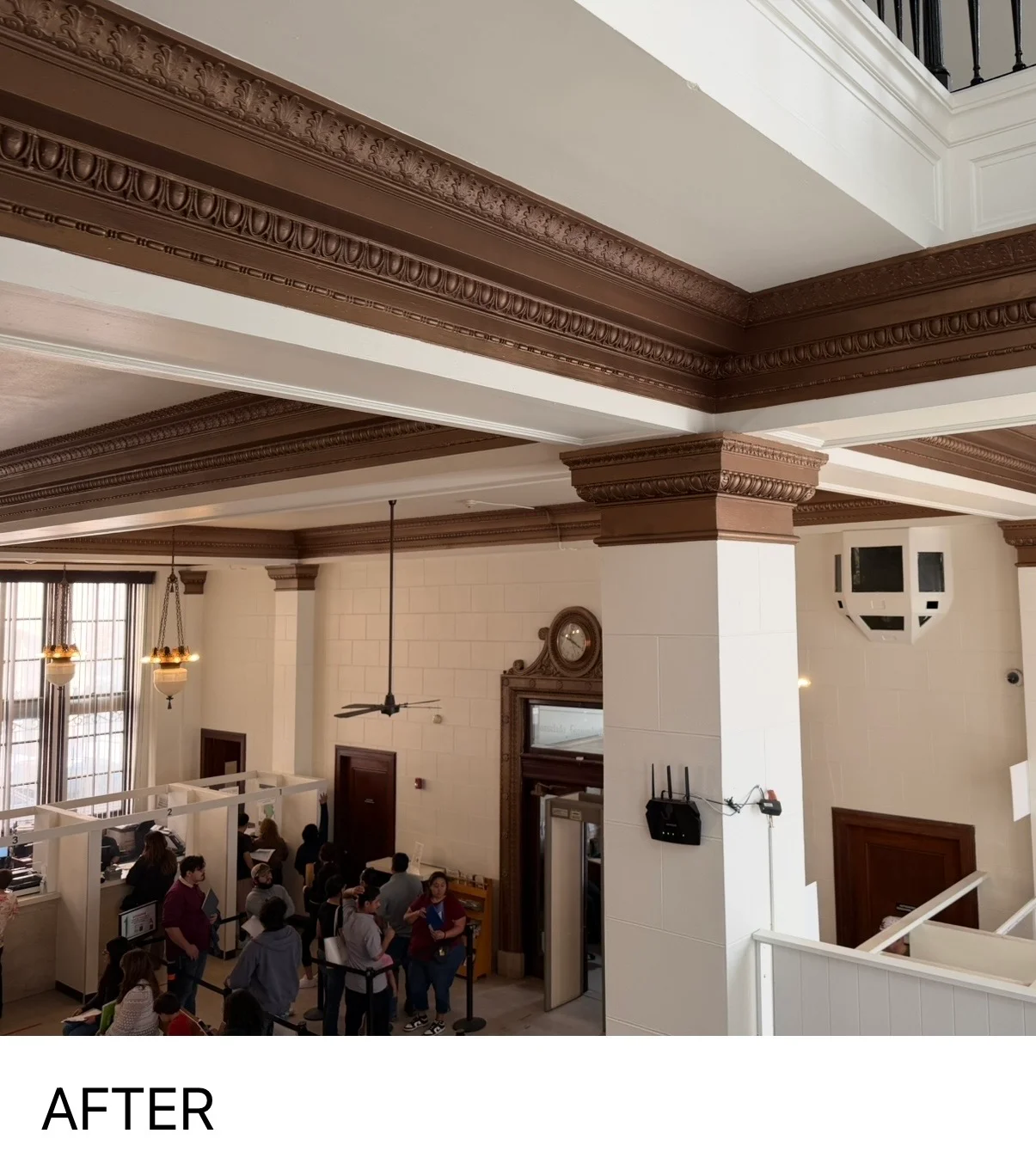 Historic interior with ornate brown crown molding, white ceiling, and restored architectural details