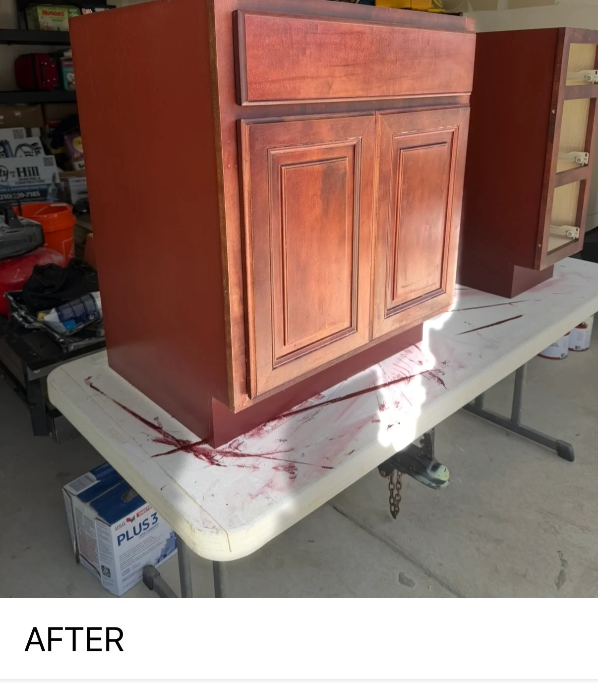 Finished cherry-stained wooden cabinet with two raised-panel doors and upper storage section