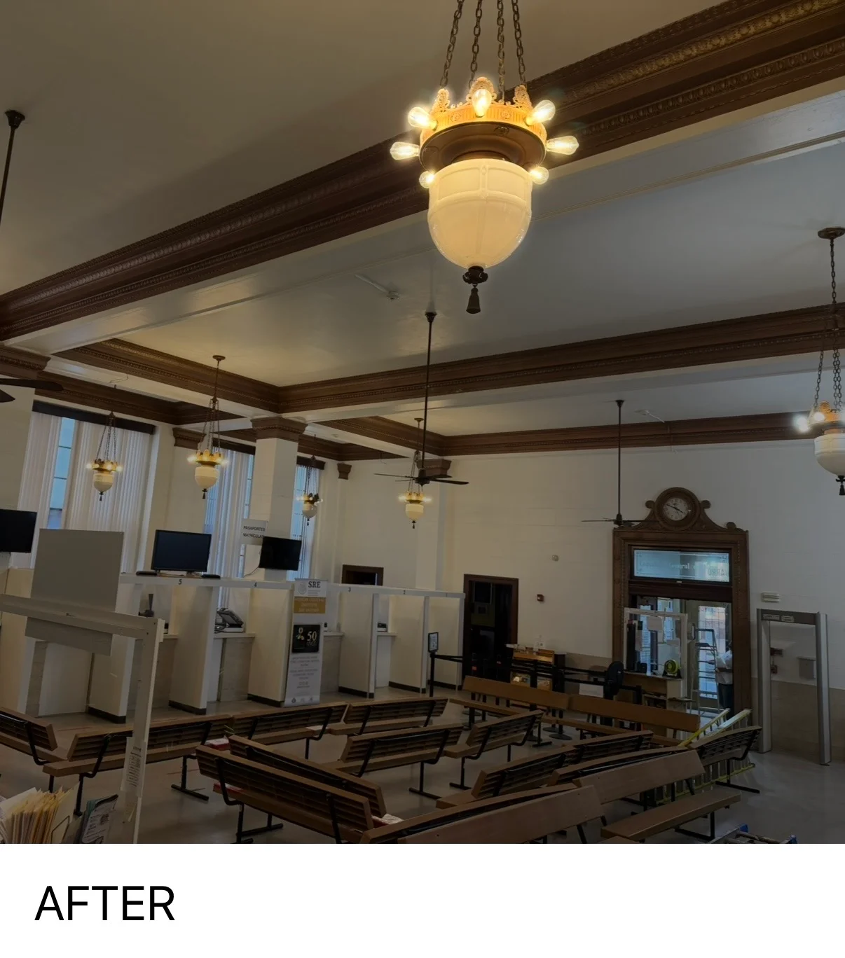 Historic interior with white painted walls, dark wood beams, and vintage pendant lighting fixtures