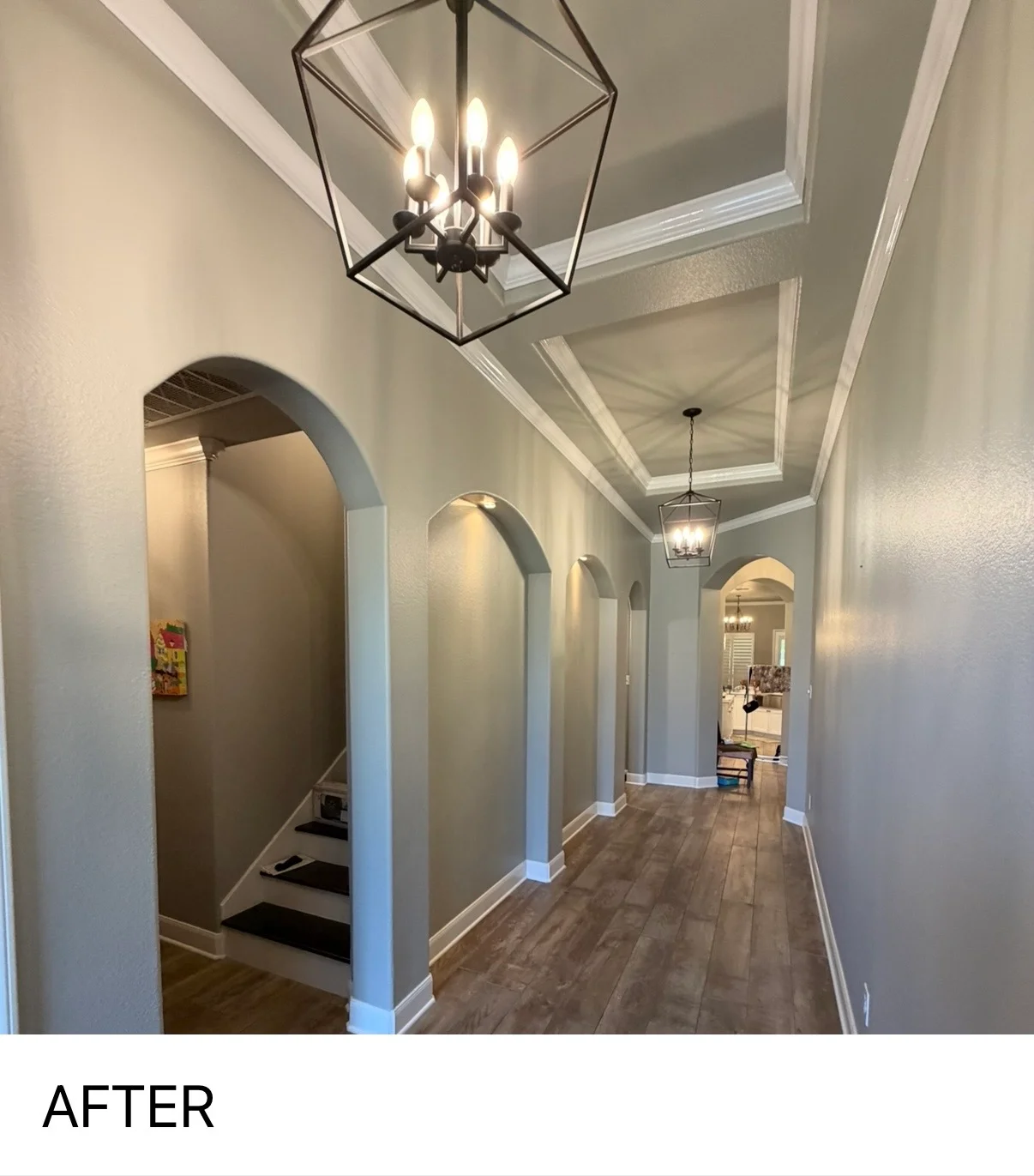 Bright hallway with arched doorways, coffered ceiling, and pendant lighting after renovation