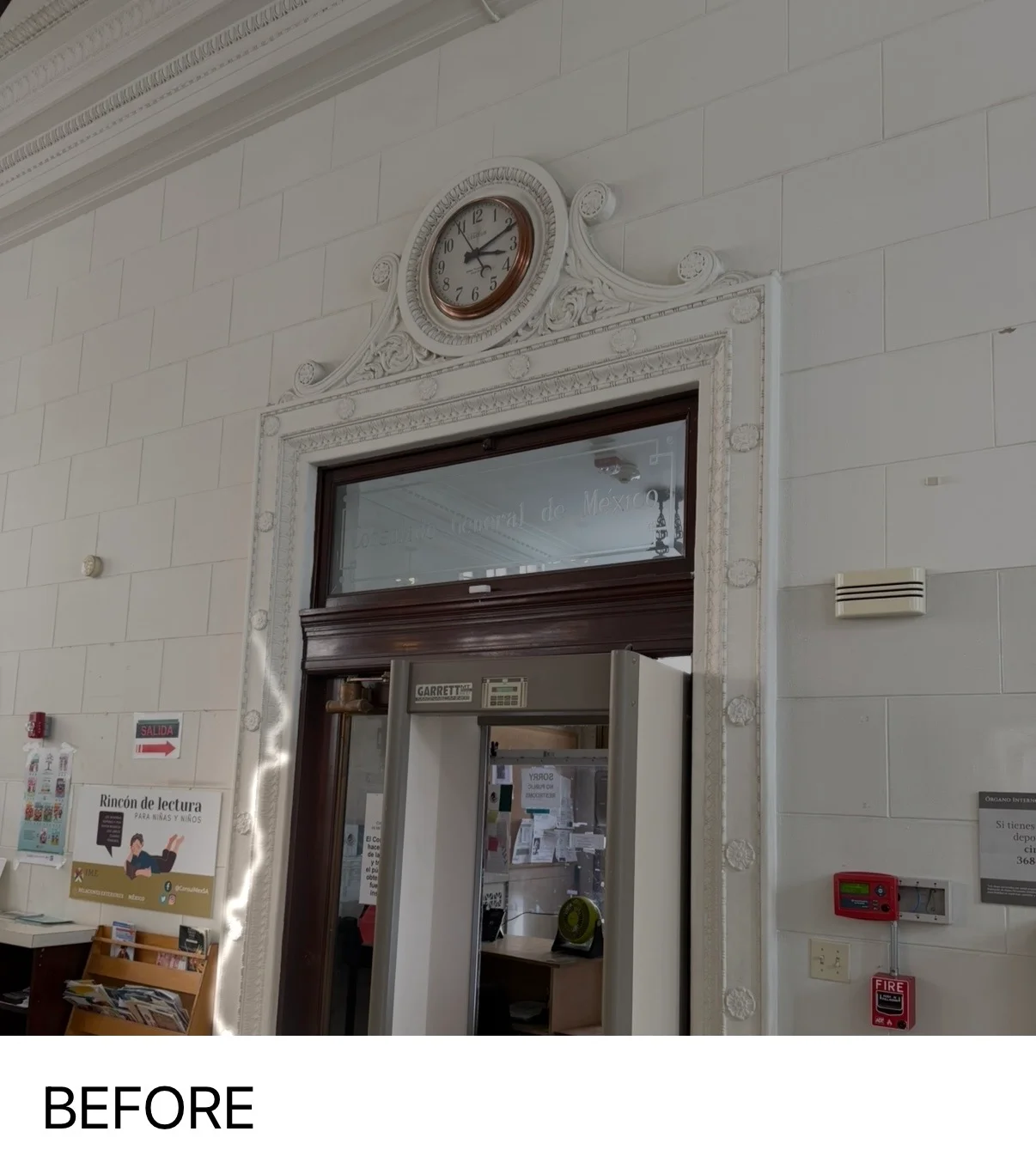 White painted interior walls with decorative trim and clock above doorway in commercial space