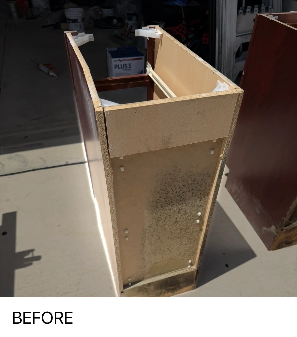 Cream-primed cabinet box with hardware holes marked, ready for finishing