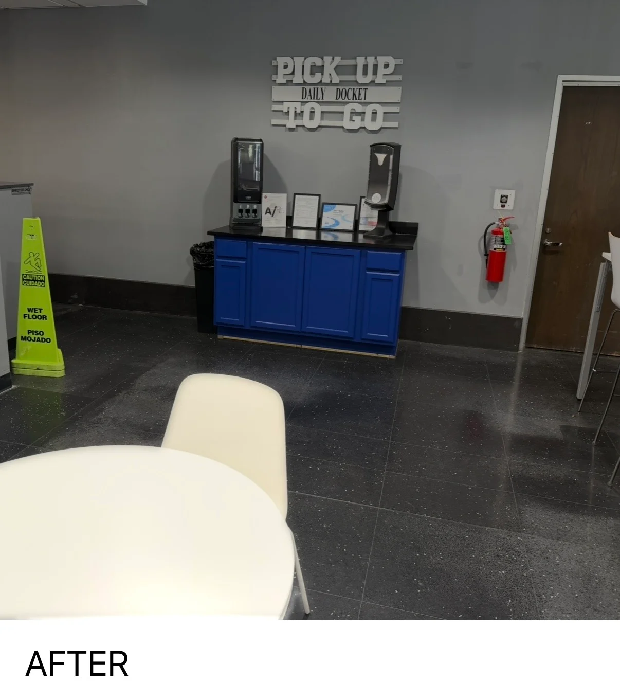 Commercial interior with gray painted walls, dark tile flooring, and blue service counter