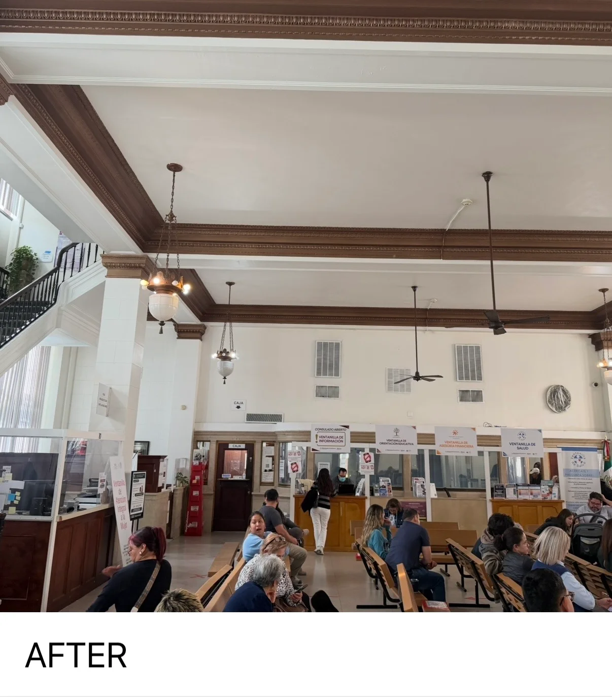 Historic building interior with painted cream walls, dark wood beams, and pendant lighting fixtures