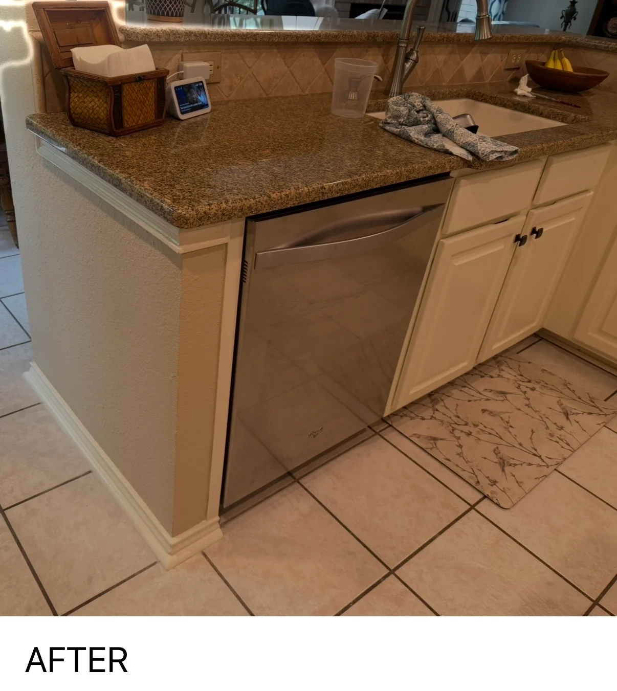 Cream painted kitchen island with granite countertop and stainless steel appliance